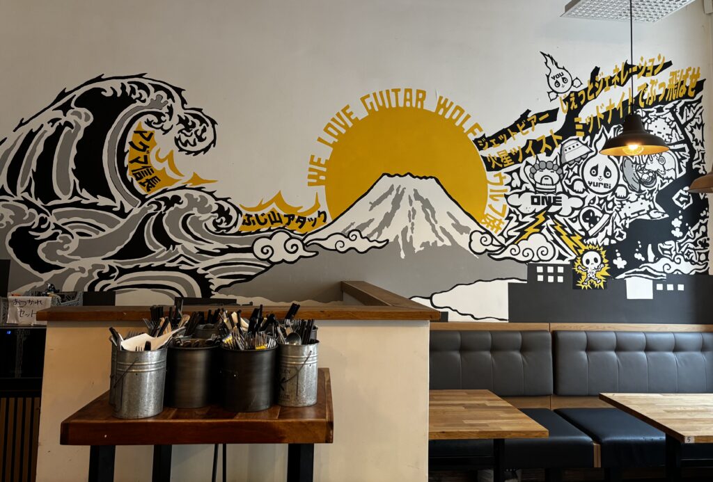 Image shows the decorative art on the back of the wall at Mama Wolf on Södermalm.
